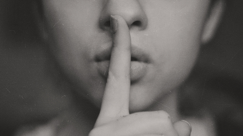 woman with finger over her lips